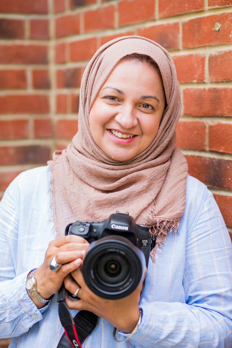 Hijabi female photographer holding a camera in North London